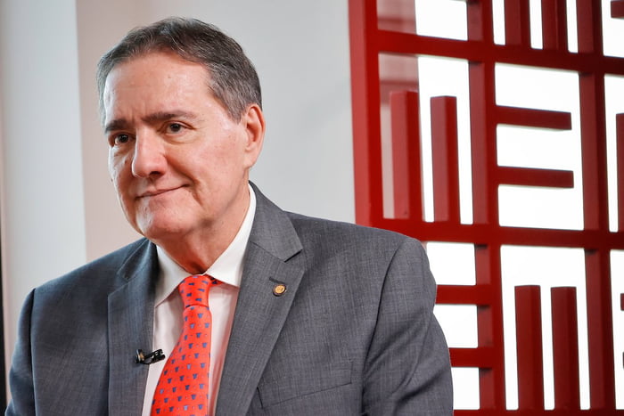 Homem de gravata vermelha de perfil - Metrópoels