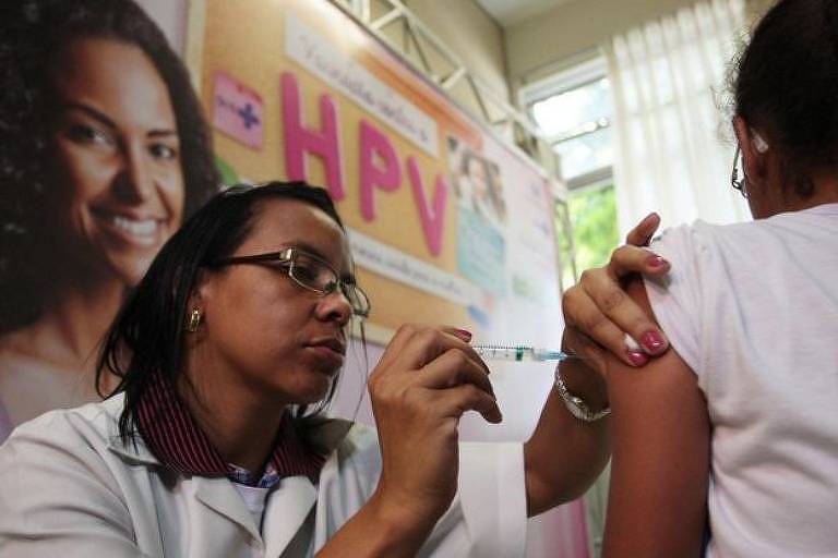 Enfermeira vacina braço de uma menina contra o HPV