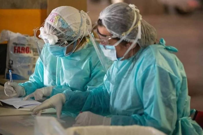 Foto colorida de duas enfermeiras com roupa de proteção