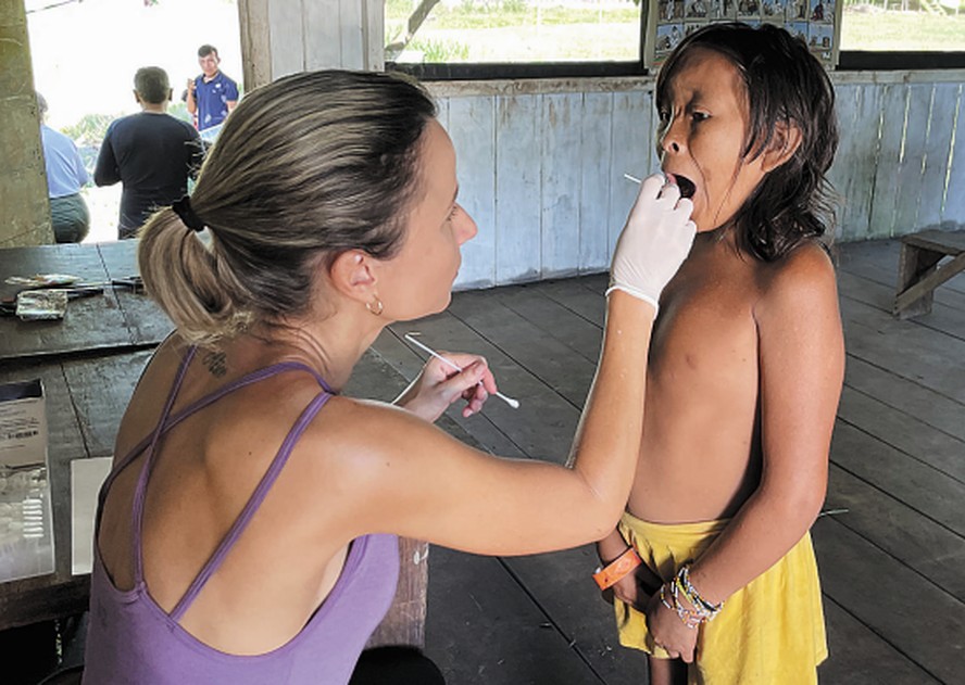 Pesquisadora com criança ianomâmi: mercúrio, fome e falta de assistência médica afetam crescimento