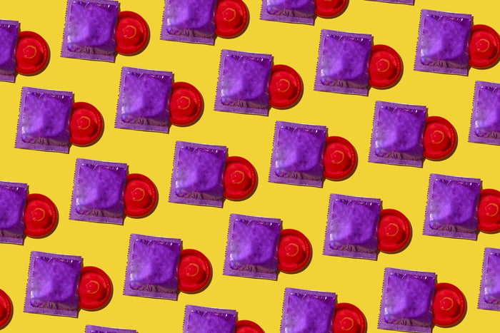 Muitos preservativos vermelhos prontos para uso em fundo amarelo