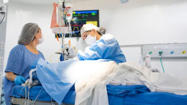profissionais de saúde atendem paciente em leito
